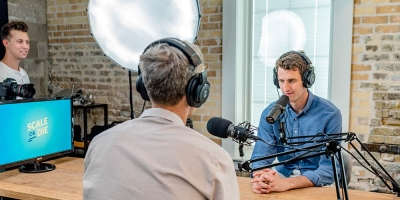 Two people wearing headphones recording a podcast