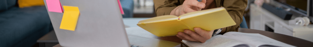 laptop, book and notebook on a desk